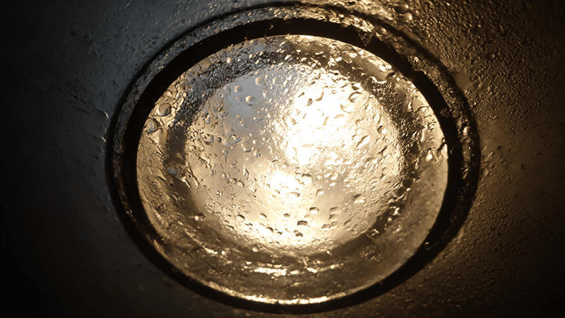 A close-up shot showing condensation inside a poorly designed downlight.