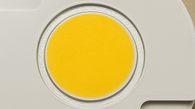 A close-up of an unlit COB LED showing the yellow phosphor coating
