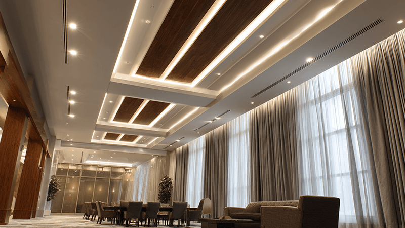 A 20-foot ceiling room with layered lighting from both narrow and wide beam downlights