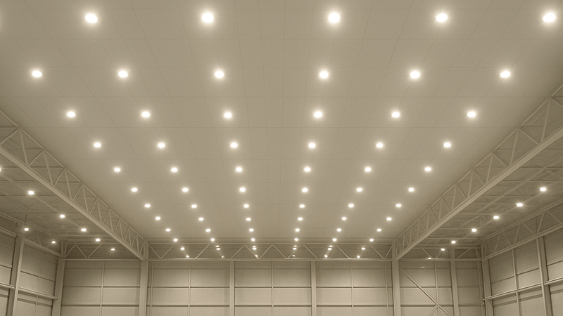 A large warehouse ceiling filled with many bright LED downlights
