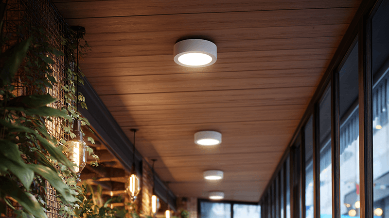 An IP65 downlight installed in the ceiling of an outdoor patio area