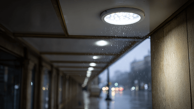 An IP54 downlight installed in a covered outdoor walkway during a light rain