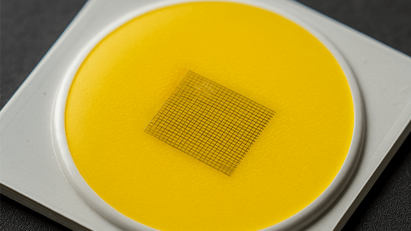 Close-up of a bare COB LED chip showing the yellow phosphor and tiny diodes underneath