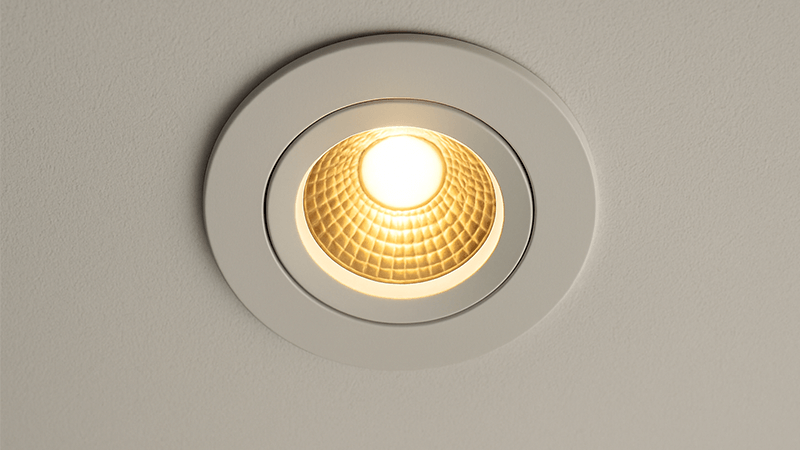 A close-up shot of a fixed LED downlight installed in a ceiling panel